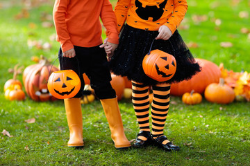 Kids with pumpkins in Halloween costumes