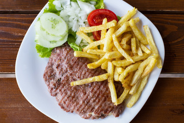 Open hamburger with french fries and salad