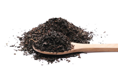 Black tea leaves in wooden spoon isolated on white background