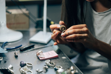 The girl works on a jewelry in the workshop