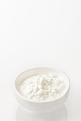 Grained cottage cheese in the white bowl