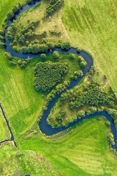 Aerial View On Winding River In Green Field