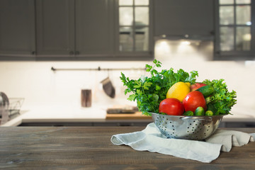 Modern kitchen with fresh vegetables on wooden tabletop, space for you and display products.