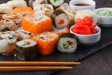 Tasty appetizing multicolored sushi rolls set, served with soy sauce and chopsticks