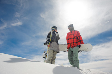 Fototapeta na wymiar Couple standing in the mountains with snowboards