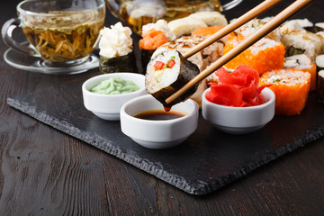 Fototapeta na wymiar Hand holding sushi Salmon roll in chopsticks with copy space for design work