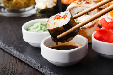 Chopsticks holding roll Philadelphia with marinated rice, cheese Philadelphia