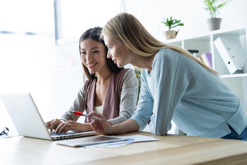 Two female colleagues in office working together.