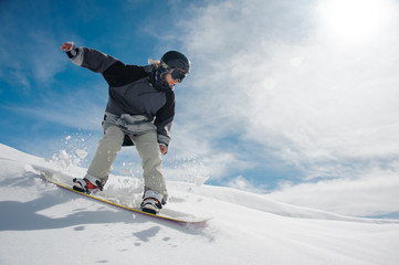 Young female snowboarder running down the mountain slope - obrazy, fototapety, plakaty