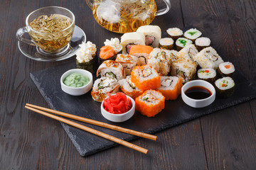 Fototapeta na wymiar Fresh and delicious maki and nigiri sushi rolls and green tea glass