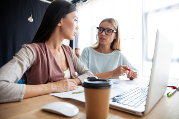 Two female colleagues in office working together.