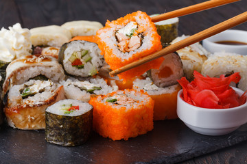 Chopsticks holding roll Philadelphia with marinated rice, cheese Philadelphia