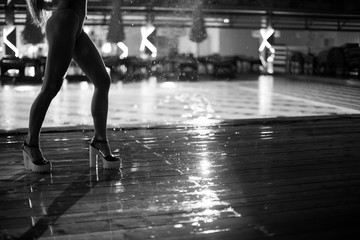 PJ or go-go dance in the rain on a wooden dance floor under an umbrella near the pool. Abstract...