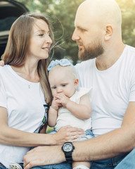 Outdoor Shot of Young Couple with Their Daughter in Love