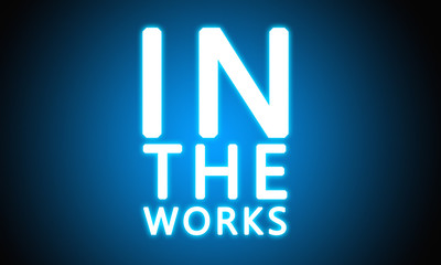 In The Works - glowing white text on blue background