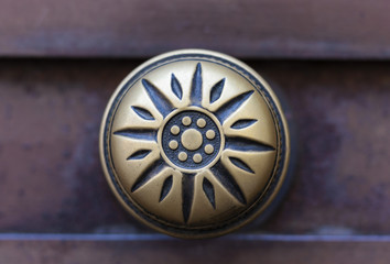 Fototapeta na wymiar Exterior vintage door handle with a bronze finish on a brown front door