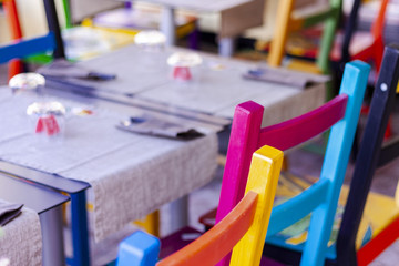 Tables with multi-colored chairs on the terrace in a cafe