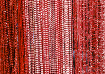 Necklaces with red and pink beads and corals in a jewelry store shop