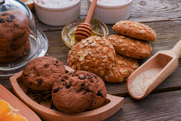 Oatmeal cookies with honey and chocolate cookies on brown wooden table. Food, holiday, cooking, baking background. Concept of home and healthy eating.