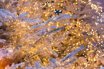 Silver Christmas tree with golden shining garlands, Christmas background.