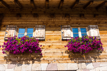 Fototapeta na wymiar Doppia finestra in Baita con fiori