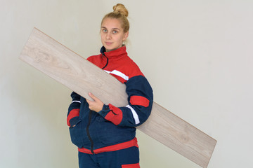 Happy young woman measuring and marking laminate floor tile, installing laminate flooring. Close-up...