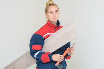 Happy young woman measuring and marking laminate floor tile, installing laminate flooring. Close-up...