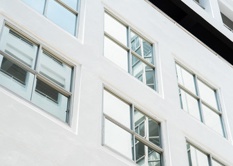 clear glass window on the white wall of high architecture building with reflection