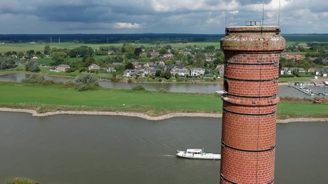 Top of old Chimney from a stone factory, with background river view. Chimney standalone in the river landscape
