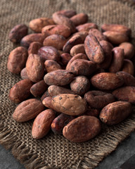 pile of cocoa seeds on rustic sackcloth in dark stage