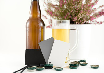 beer bottles with glass vase and plant on white background