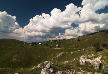 A remote settlement Mala Crna Gora in the Durmitor national park. Nice contrast of the rocky greenish grass and huge clouds.