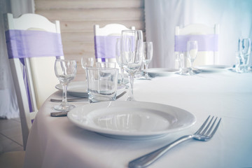 Empty plate, wine glasses, fork and knives on the table