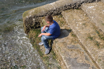 little boy on steps, playing in water (Puget Sound, which is a inlet that leads to the Pacific...
