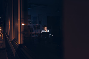 Asian businessman working at his desk in a dark office 