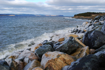 Fototapeta na wymiar Ice covered rocks on a rocky beach, Conception Bay South, Newfoundland and Labrador, Canada