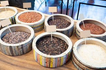 Selection of raw white, purple, black, red rice in bowls. Rich in nutrients and good source of vitamins, minerals, antioxidant, high in fiber. Healthy eating and eat well concept. Mock up label ready.