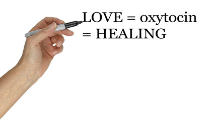 Love equals oxytocin equals healing concept - hand holding marker pen pointing to the words LOVE =...