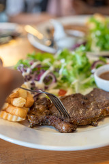 Beef steak with vegetable salad and chips on white plate