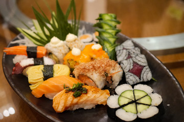Selection of tasty and delicious Sushi. Most popular Japanese food. Nigiri Sushi is raw seafood on top of vinegared rice. Maki Sushi is rice wrapped in seaweed. Healthy eating and eat well concept.