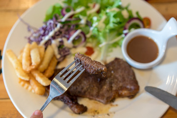 Beef steak with vegetable salad and chips on white plate