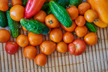Tomatoes, cucumbers, red and yellow peppers on the table