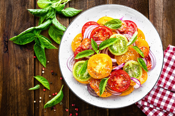 Tomato salad. Fresh vegetable salad with tomatoes, onion and basil