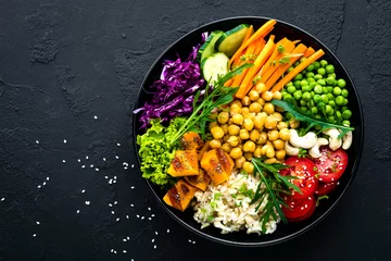 Photo sur Plexiglas Plats de repas Bol avec riz brun, concombre, tomate, pois verts, chou rouge, pois chiche, salade de laitue fraîche et noix de cajou. Une alimentation saine et équilibrée