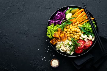 Photo sur Plexiglas Plats de repas Bowl dish with brown rice, cucumber, tomato, green peas, red cabbage, chickpea, fresh lettuce salad and cashew nuts. Healthy balanced eating