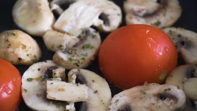 Tomato and mushrooms cooking in pan for a traditional English breakfast