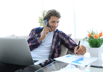 modern man working with financial documents in living room © ASDF