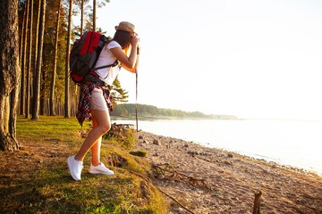 Nature Photographer taking pictures outdoors during hiking trip.