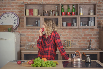 Woman with apple in the kitchen