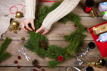 Woman making Christmas wreath. Top view